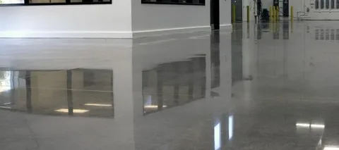 A smooth, high-gloss reflective floor showcasing the smooth finish of polished concrete steps and surfaces